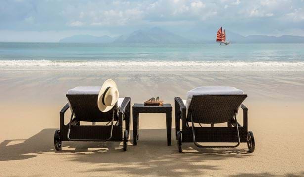 two sun loungers on the beach in a sunny setting with a view of the datai bay