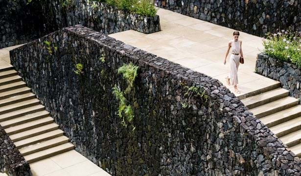 woman walking up wide stone stairs at the resort