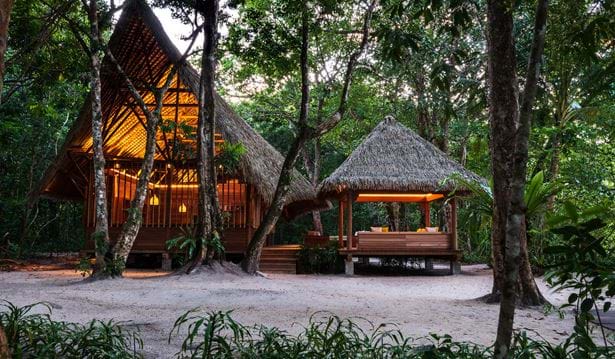 exterior shot of the nature centre in the evening with straw roof and comfy seating area