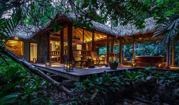 exterior shot of the spa in the evening time all lit up with a jacuzzi and chairs