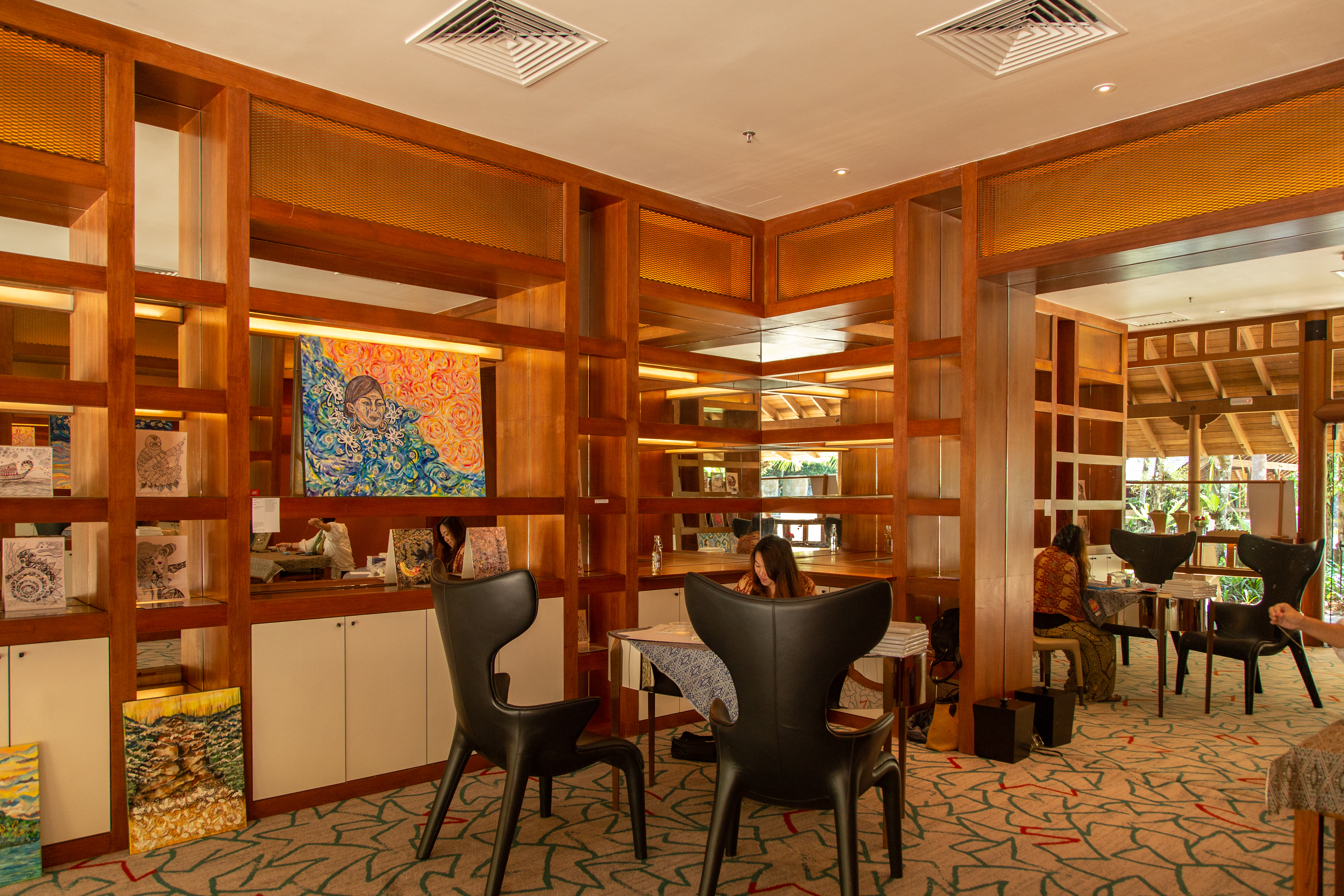 art exhibition showcasing various pieces of art with two woman making art