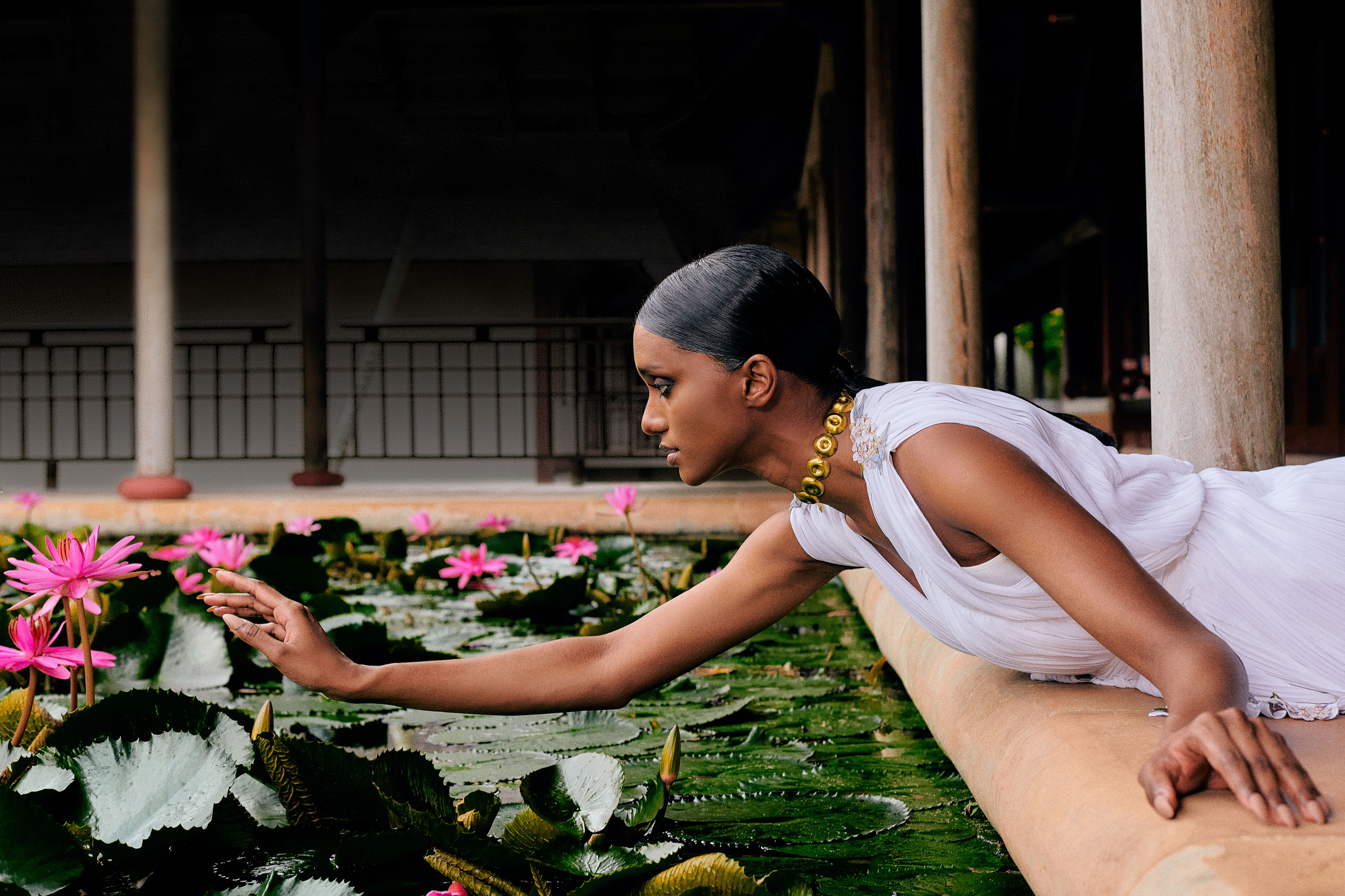fashion designer alia bastamam at the resort reaching over to a flower