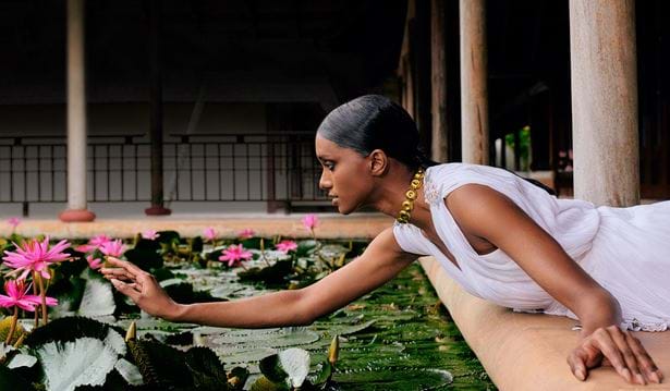 fashion designer alia bastamam at the resort reaching over to a flower