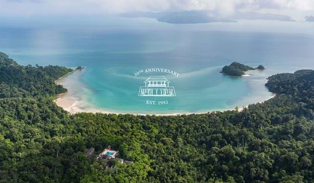 Wide aerial shot of the resort with the datai bay in the background and the 30th anniversary logo in the middle