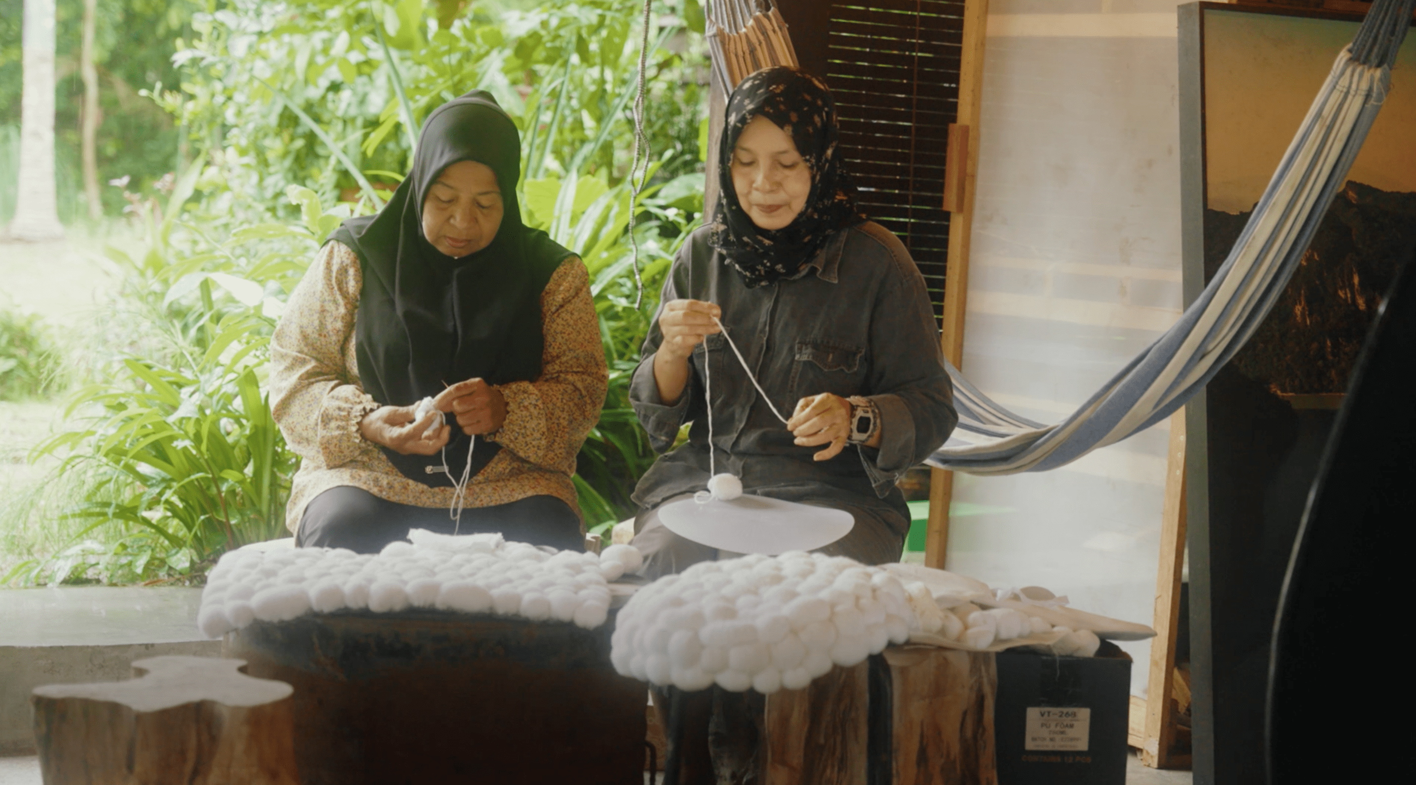 Two ladies threading threads
